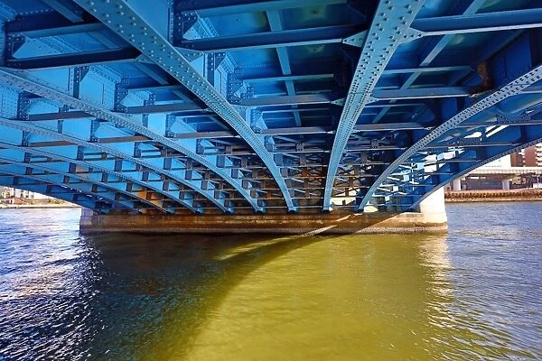 View of ironwork under the blue bridge over the Sumida River in Asakusa, Tokyo, Japan
