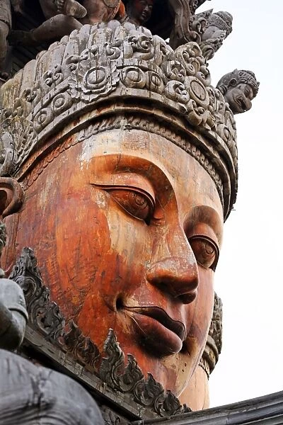 Wooden carving on the Sanctuary of Truth Temple, Prasat Sut Ja-Tum, Pattaya, Thailand showing a wood statue of a face