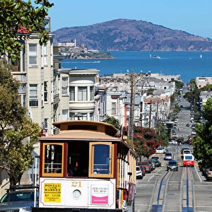 Street scene with a Cable Car tram and Alcatraz Prison island in San Franciso, California