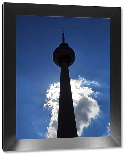 Silhouette of the Berlin TV Tower, Fernsehturm, television tower and a cloud in Berlin, Germany