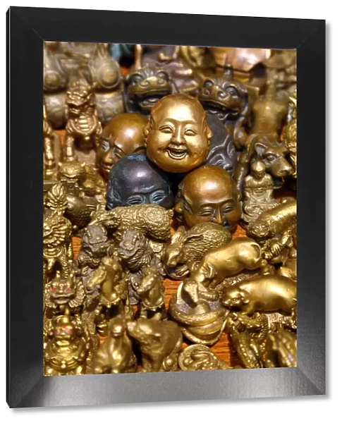Pile of brass figures including laughing Buddha head in the Old City, Shanghai, China