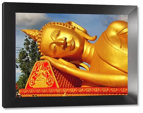 Giant gold reclining sleeping Buddha statue near Wat That Luang Temple, Vientiane, Laos