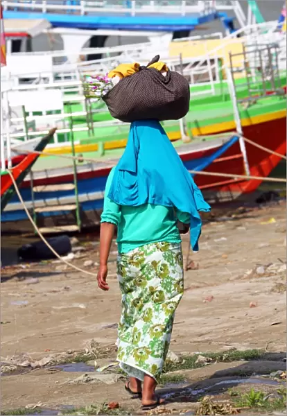 Woman carrying bag on her head in Old Bagan, Bagan, Myanmar (Burma)