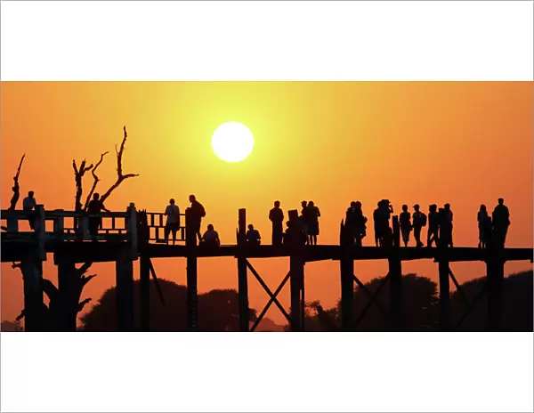 Silhouettes on the U Bein Bridge at sunset, Amarapura, Myanmar