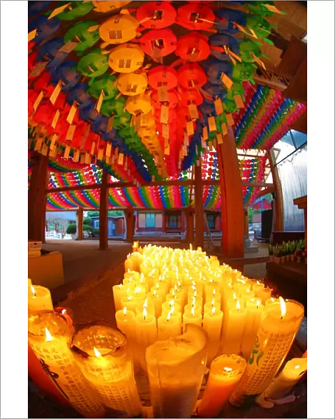 Rainbow coloured paper lanterns and candles at an altar in Bongeunsa Temple in Seoul