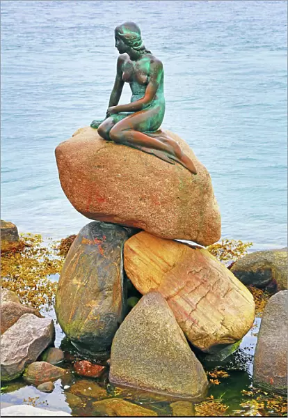 Little Mermaid statue sitting on rocks in Copenhagen, Denmark
