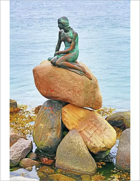 Little Mermaid statue sitting on rocks in Copenhagen, Denmark