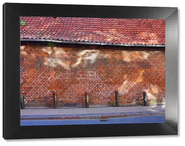 Street scene with old brick wall with light reflection in Copenhagen, Denmark