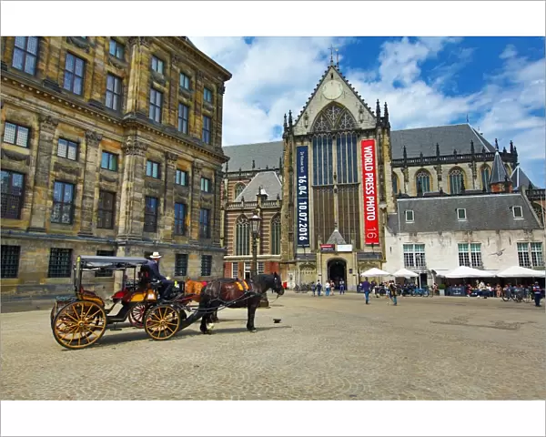 Horse drawn carriage and the Nieuwe Kerk church in Dam Square in Amsterdam, Holland