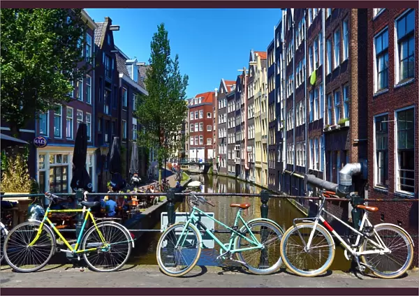 Bicycles on a bridge on the Oudezijds Achterburgwal canal and houses in Amsterdam
