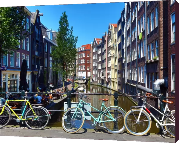 Bicycles on a bridge on the Oudezijds Achterburgwal canal and houses in Amsterdam