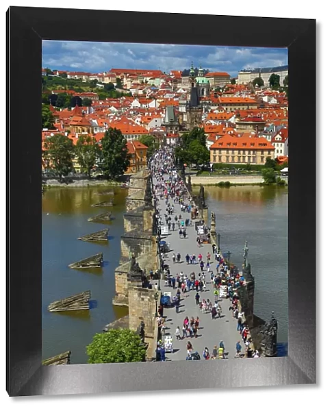 Tourists walking over the Charles Bridge over the Vltava River in Prague, Czech Republic