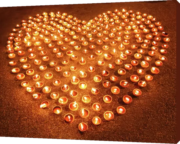 Love heart shape made out of burning candles and light
