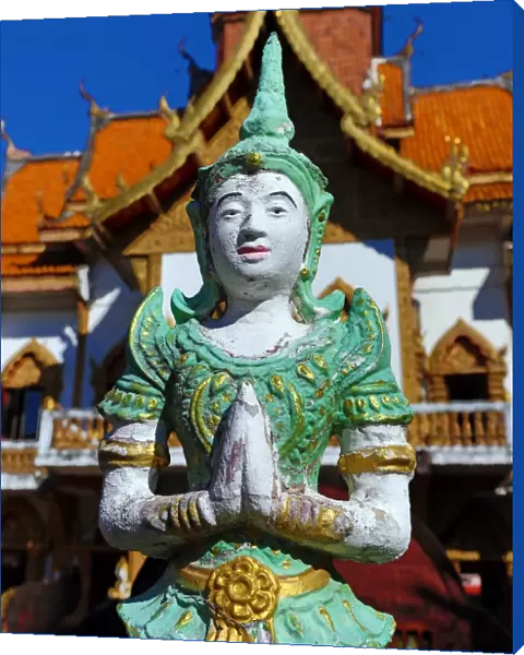 Praying statue in front of the ordination hall at Wat Buppharam Temple in Chiang Mai