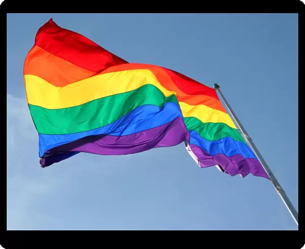 Rainbow Flag flying against blue sky - Symbol of Gay Pride