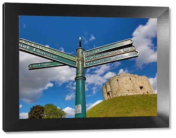 Tourist information signpost and Cliffords Tower at York Castle in York, Yorkshire