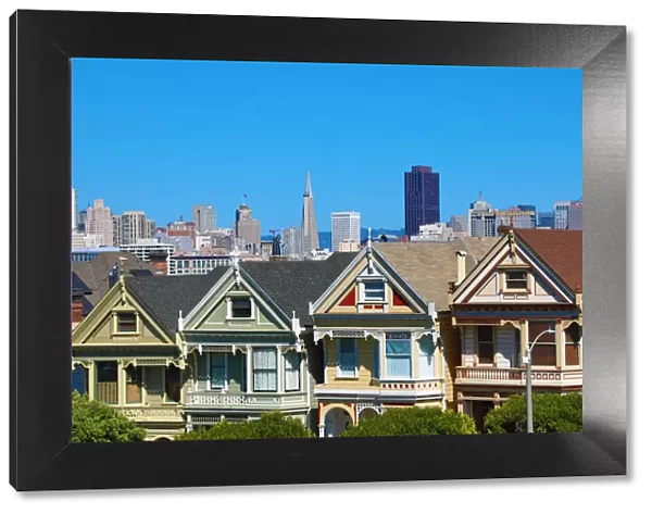 Painted Ladies Victorian houses near Alamo Square and city skyline, San Franciso
