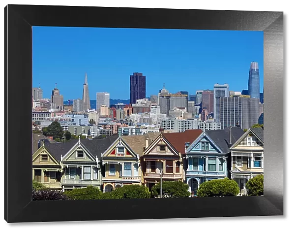 Painted Ladies Victorian houses near Alamo Square and city skyline, San Franciso