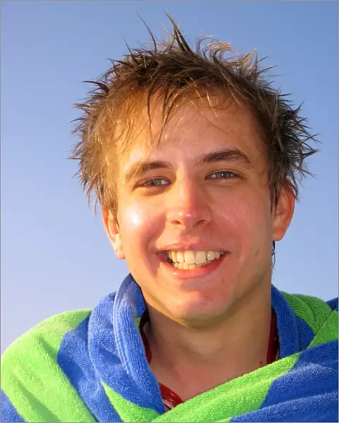 Portrait of a smiling man on summer holiday wrapped in a towel