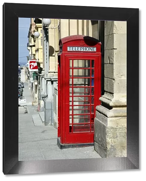 Red English telephone box in the street in Valletta, Malta