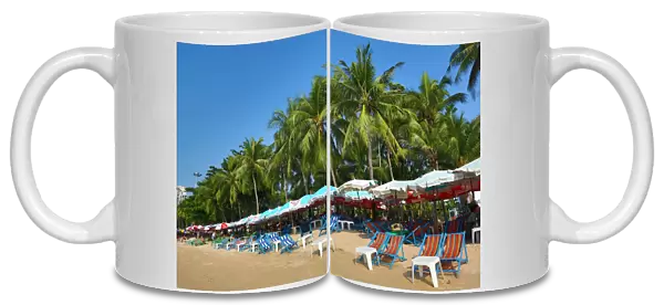 Tropical beach scene with umbrellas on the seafront of Pattaya, Thailand