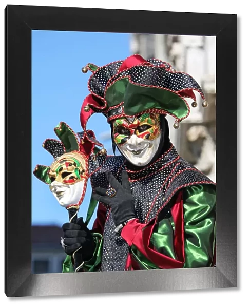 Man wearing a jester mask and costume at the Venice Carnival