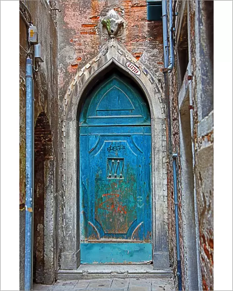 Old blue door in a stone wall in Venice, Italy