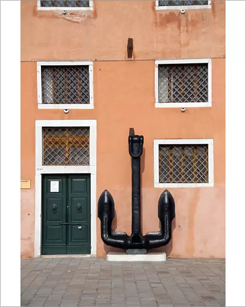 Anchor and the wall of a building with windows in Venice, Italy