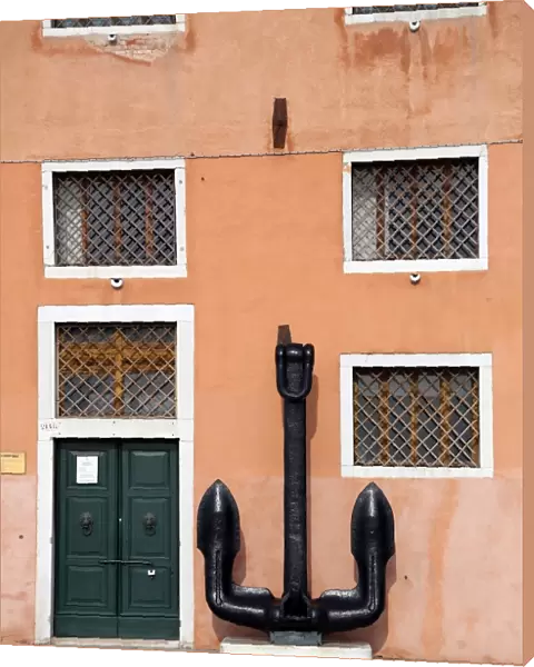 Anchor and the wall of a building with windows in Venice, Italy