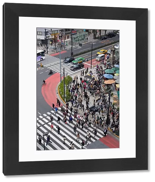 Street scene showing crowds of people crossing the street on a pedestrian crossing in Harajuku, Tokyo, Japan