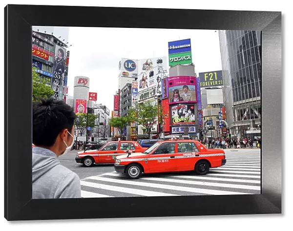 Pedestrian crossing and street scene with Japanese taxi cabs in Shibuya, Tokyo, Japan