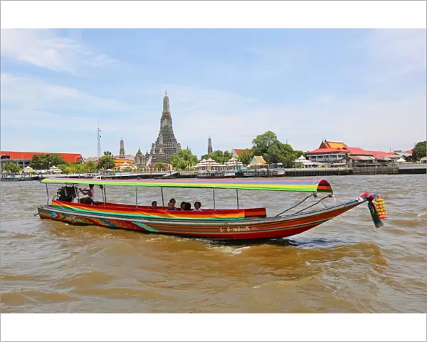 Traditional Thai boat on the Chao Phraya River and Wat Arun, Temple of the Dawn, Bangkok, Thailand