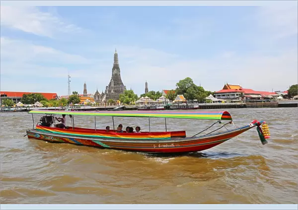 Traditional Thai boat on the Chao Phraya River and Wat Arun, Temple of the Dawn, Bangkok, Thailand