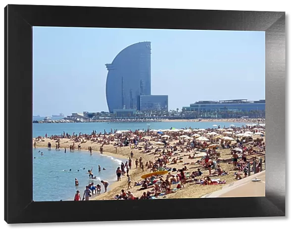 Scene of holiday crowds on the crowded beach and the W hotel, Barcelona, Spain