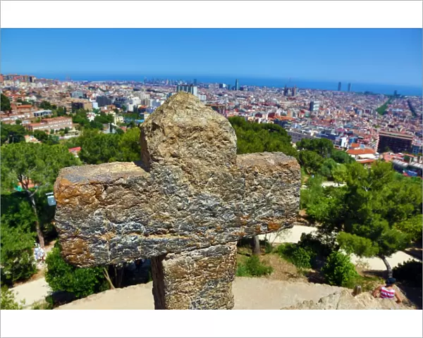 General view of the city skyline and a cross from Parc Guell park in Barcelona, Spain