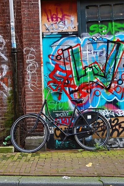 Bicycle and colourful graffiti street scene in Amsterdam, Holland