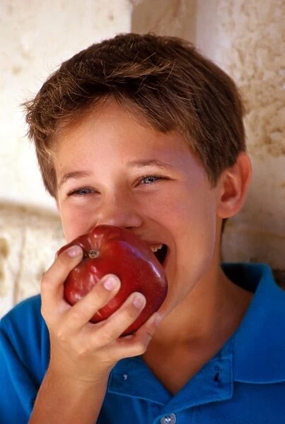 Boy eating apple. Boy eating red apple