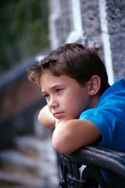Boy thinking, leaning on his arms