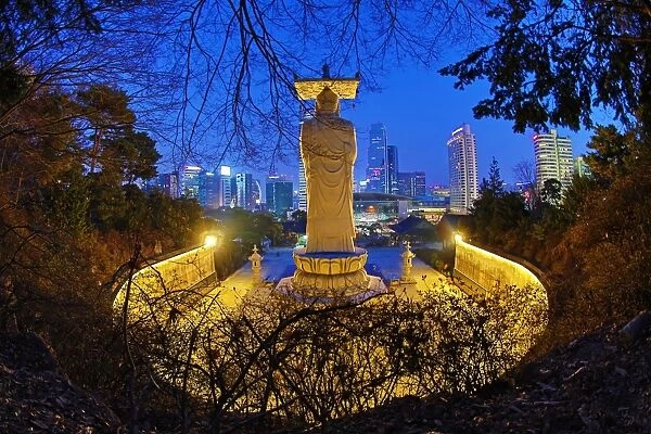 Buddha statue and city skyline, Bongeunsa Temple, Seoul, Korea