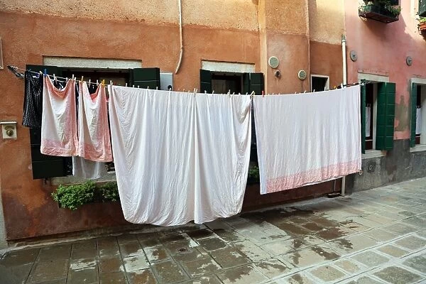 Clothes hanging on a washing line across a street on washday in Venice, Italy