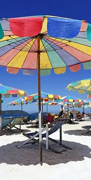 Colourful beach umbrellas and deckchairs for a summer holiday on a tropical sandy beach, Phuket, Thailand