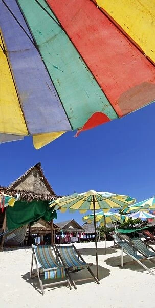 Colourful beach umbrellas and deckchairs for a summer holiday on a tropical sandy beach, Phuket, Thailand