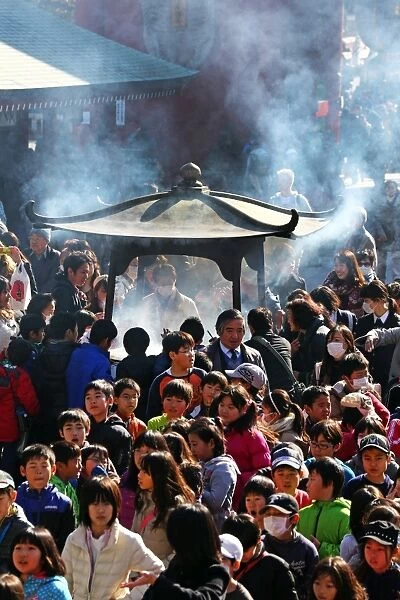 Crowds of people burning incense at the Shinto Shrine at Senso-Ji Bhuddist Temple in Asakusa in Tokyo, Japan