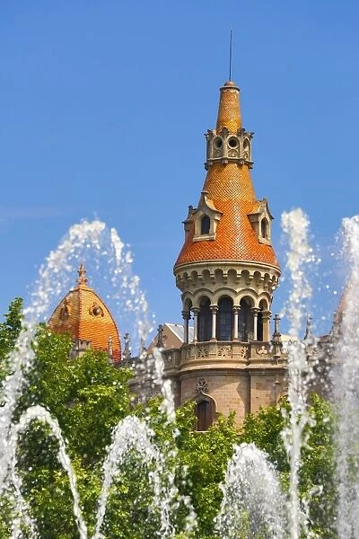 Fountain in the Placa de Catalunya and turret roofs of buildings in the Passeig de Gracia in Barcelona, Spain