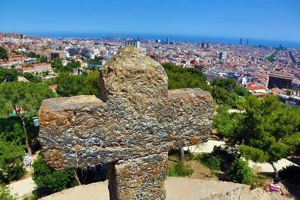 General view of the city skyline and a cross from Parc Guell park in Barcelona, Spain