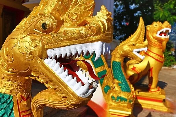 Gold Naga statue with teeth near Wat That Luang Temple, Vientiane, Laos