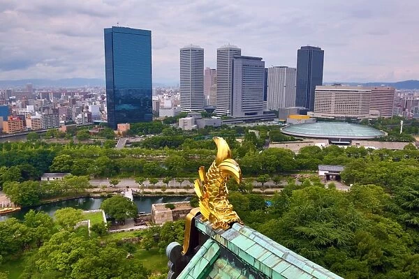 Golden fish roof decoration on Osaka Castle and city skyline, Osaka, Japan
