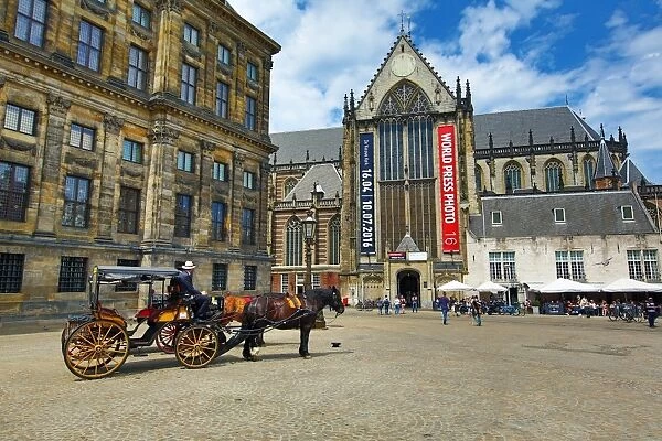 Horse drawn carriage and the Nieuwe Kerk church in Dam Square in Amsterdam, Holland