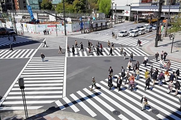 Japanese street scene showing crowds of people crossing the street on a pedestrian crossing in Ginza, Tokyo, Japan