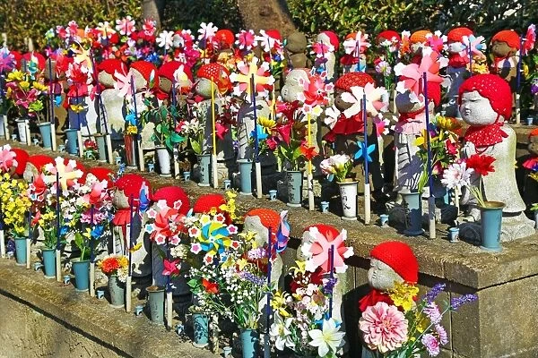 Jizo statues and pinwheel windmill toys in the Zojoji Temple cemetery garden in Tokyo